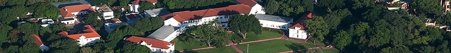 A panoramic aerial view along the hotel's red-roofed wings, gardens and lawns.